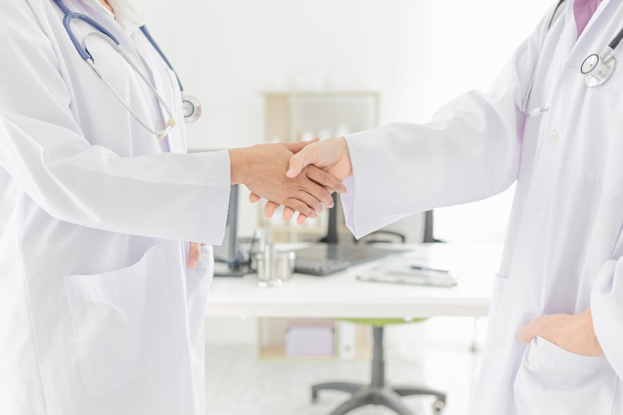 two doctor shaking hand together in hospital, hand in hand, be i