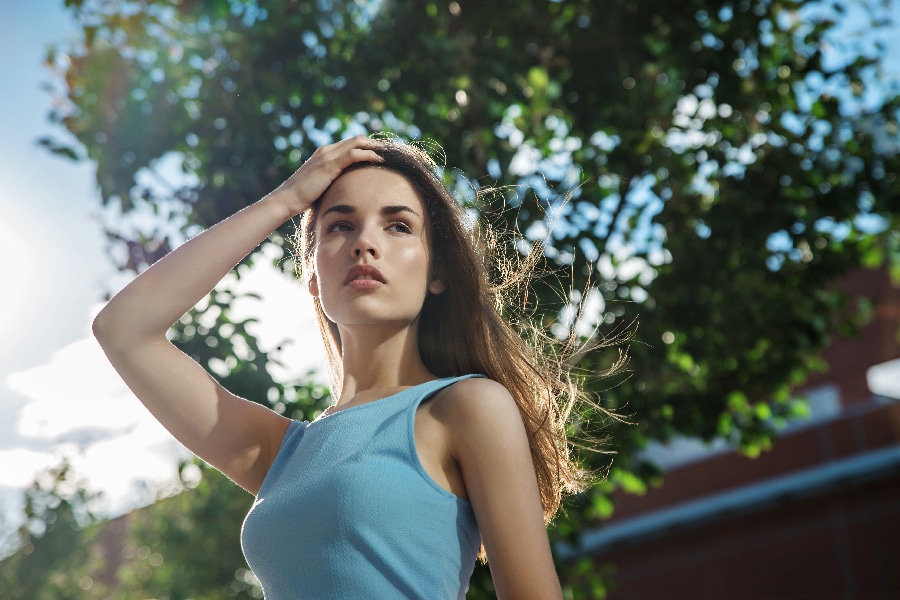 Beautiful fashion young woman with blowing hair posing in the ci