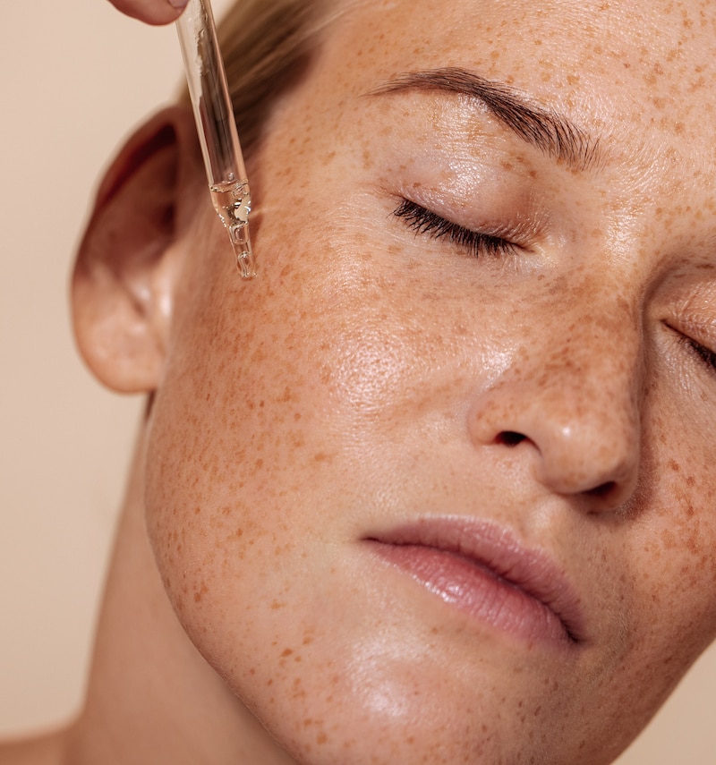 woman applying skincare to her face woman applying skincare to her face