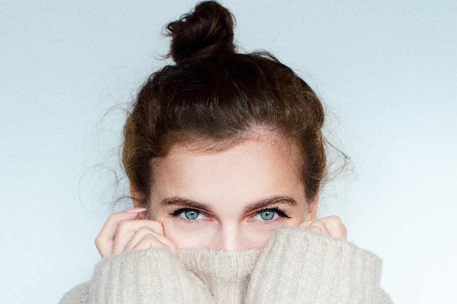 Winter portrait of a beautiful curly woman with blue eyes in a w